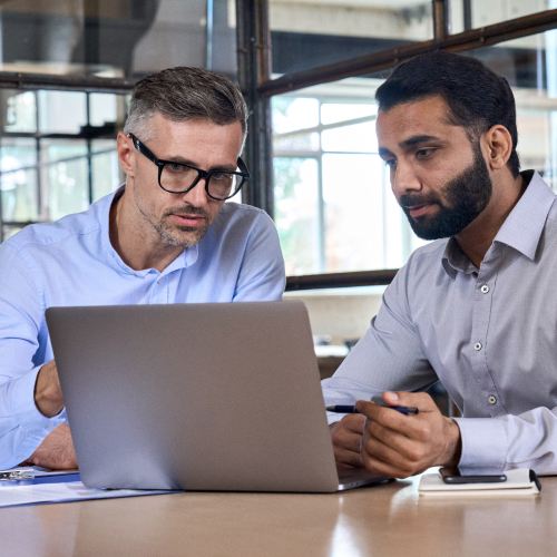Two business people consulting in front of laptop